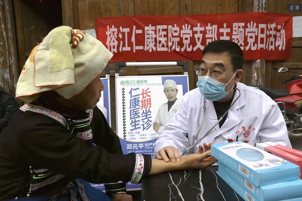 图1：2025年12月19日，在贵州省黔东南苗族侗族自治州榕江县平阳乡硐里村侗寨，医护人员在为村民把脉。.JPG