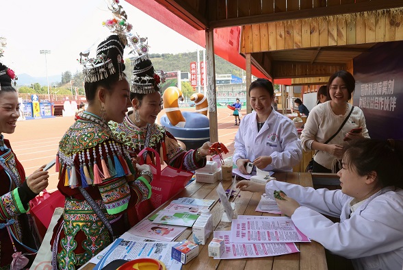 图11：2026年3月13日，在贵州省黔东南苗族侗族自治州榕江县城北新区“村超”足球场，榕江县妇幼保健院医务人员在为“村超”拉拉队员普及“两癌”免费筛查相关知识。.JPG